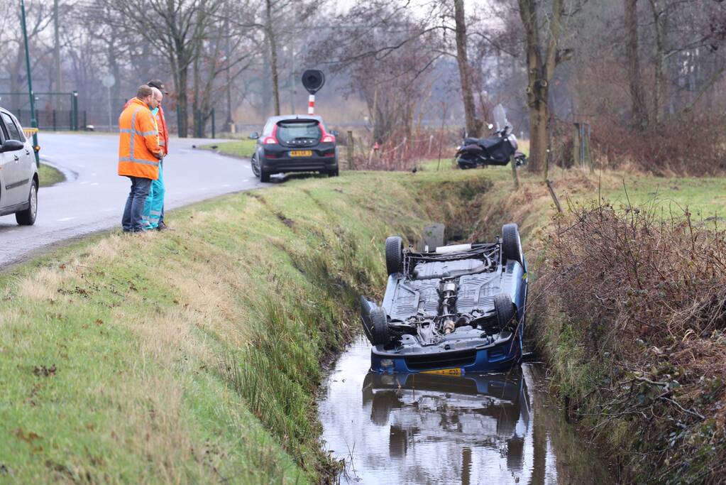 Auto vliegt uit bocht en komt ondersteboven in sloot