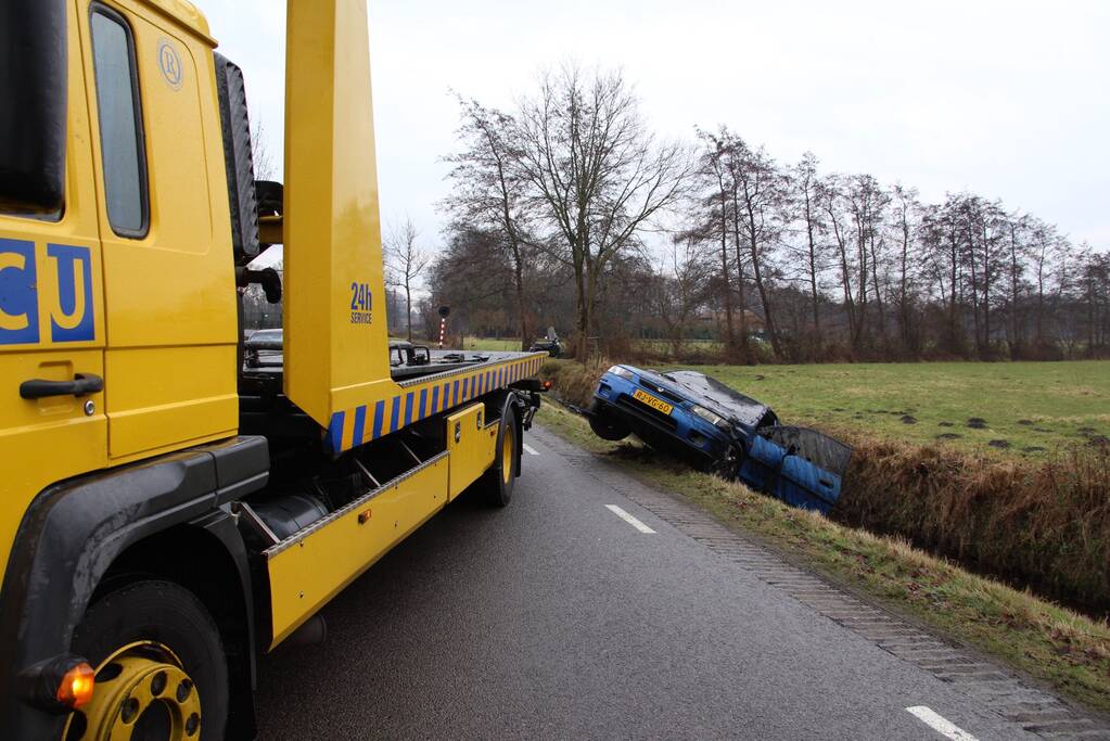 Auto vliegt uit bocht en komt ondersteboven in sloot