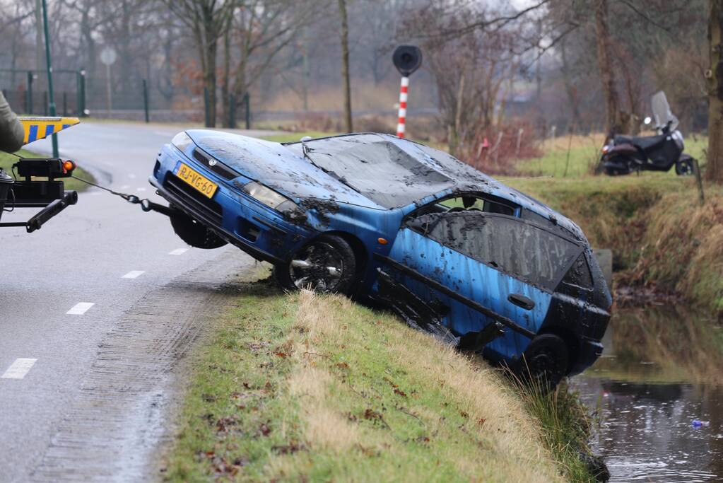 Auto vliegt uit bocht en komt ondersteboven in sloot