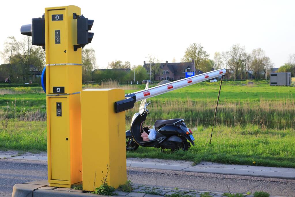 Scooterrijdster rijdt tegen slagboom