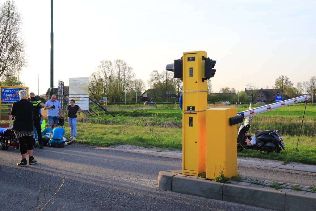 Scooterrijdster rijdt tegen slagboom