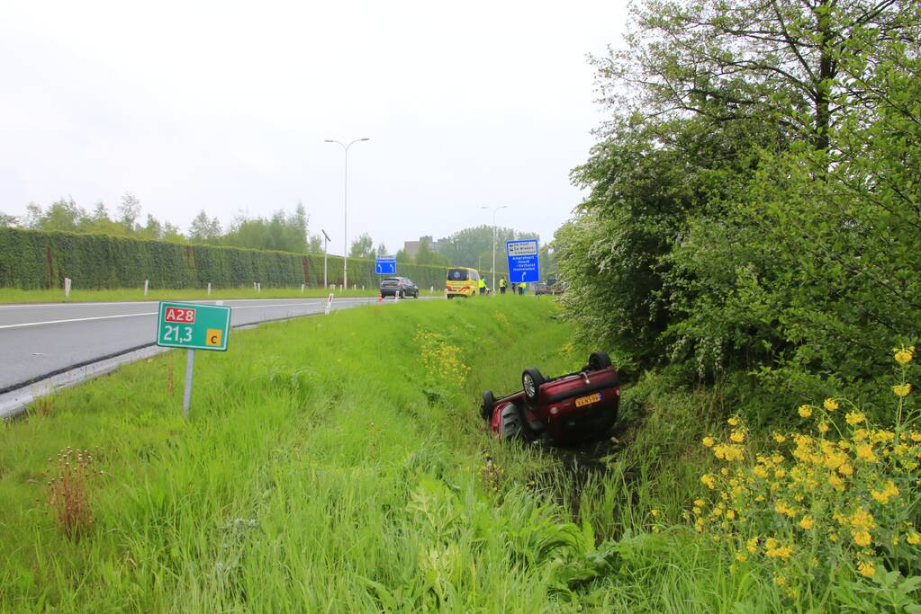 Auto te water geraakt op afrit snelweg