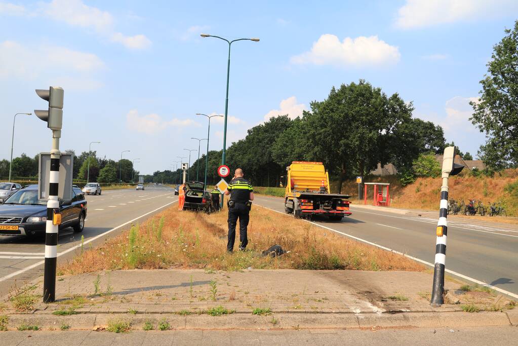 Automobilist vliegt over vluchtheuvel en ramt stoplicht