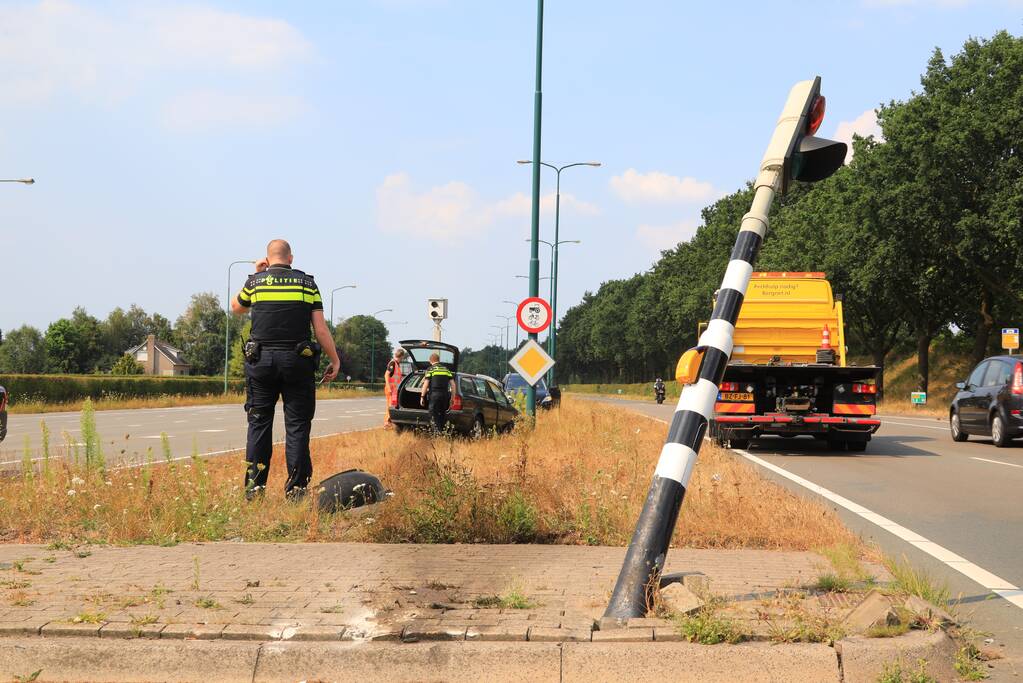 Automobilist vliegt over vluchtheuvel en ramt stoplicht