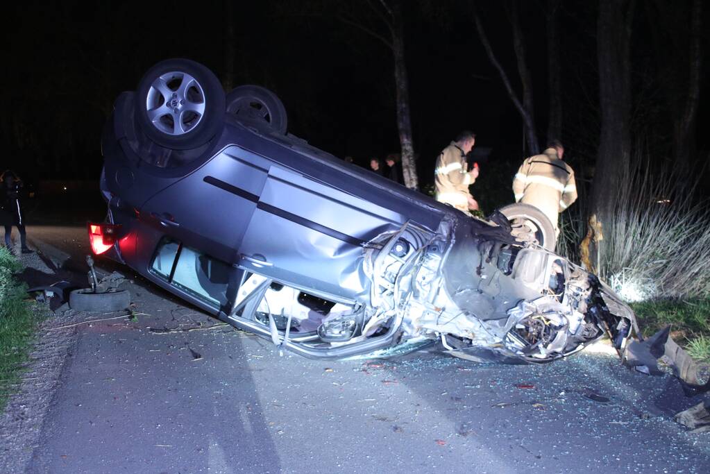 Auto beland op zijn dak na botsing met boom