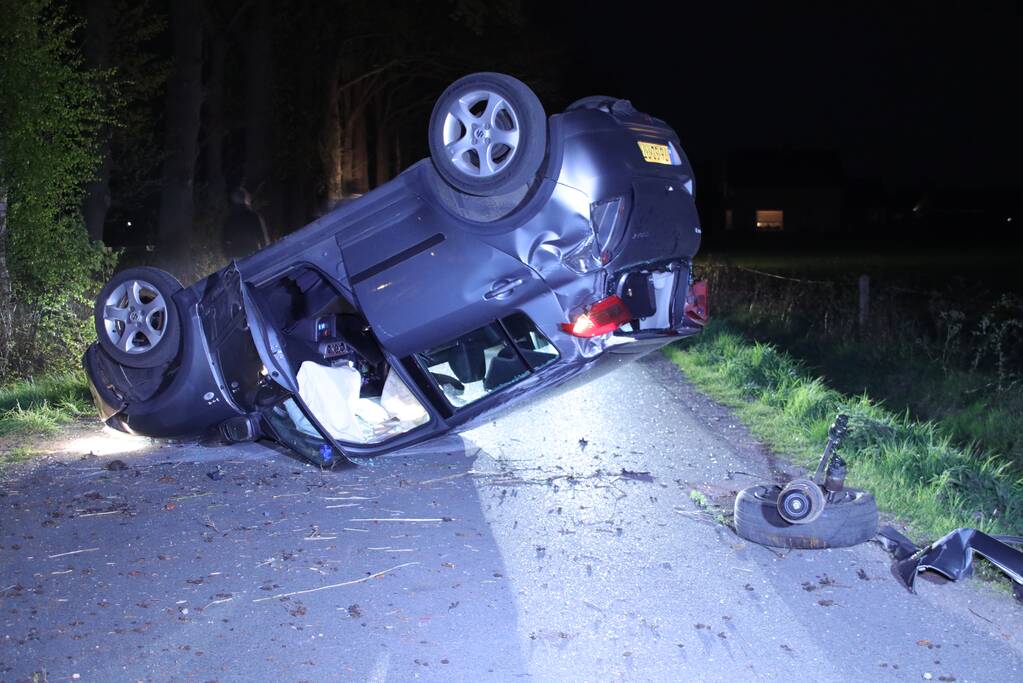 Auto beland op zijn dak na botsing met boom