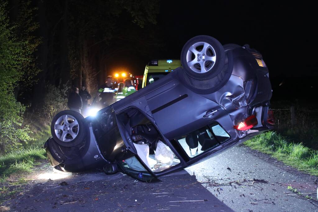 Auto beland op zijn dak na botsing met boom