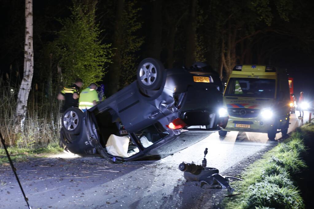 Auto beland op zijn dak na botsing met boom