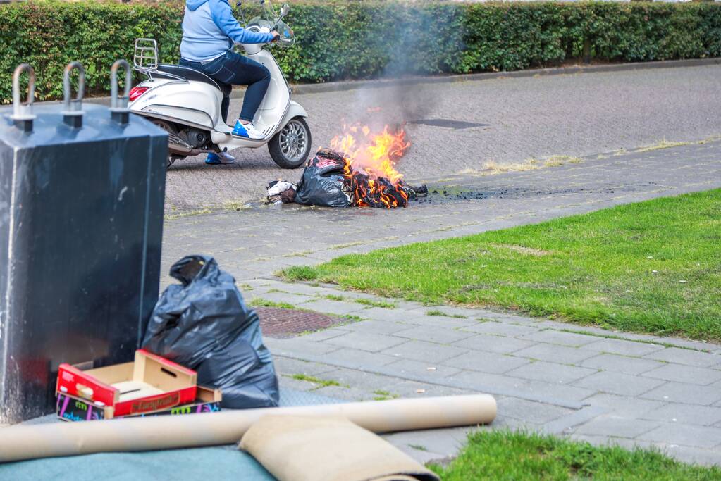 Omstanders blussen brand in kledingzak