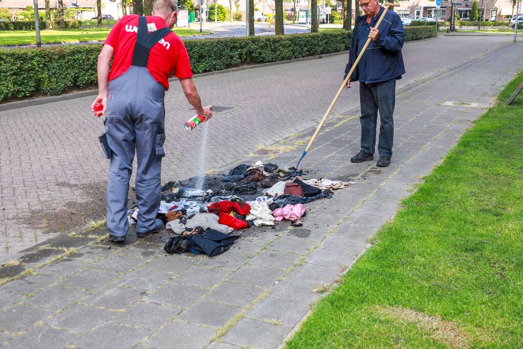 Omstanders blussen brand in kledingzak