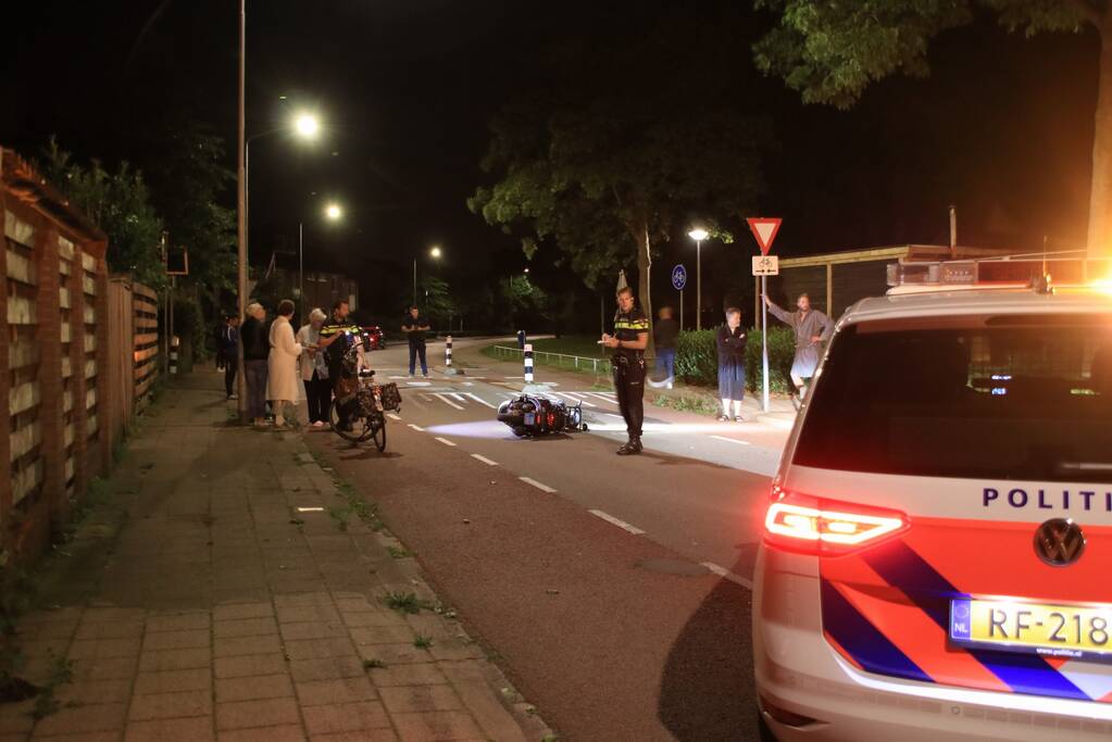 Snorscooter klapt op paal bij oversteekplaats, jonge dame buiten westen