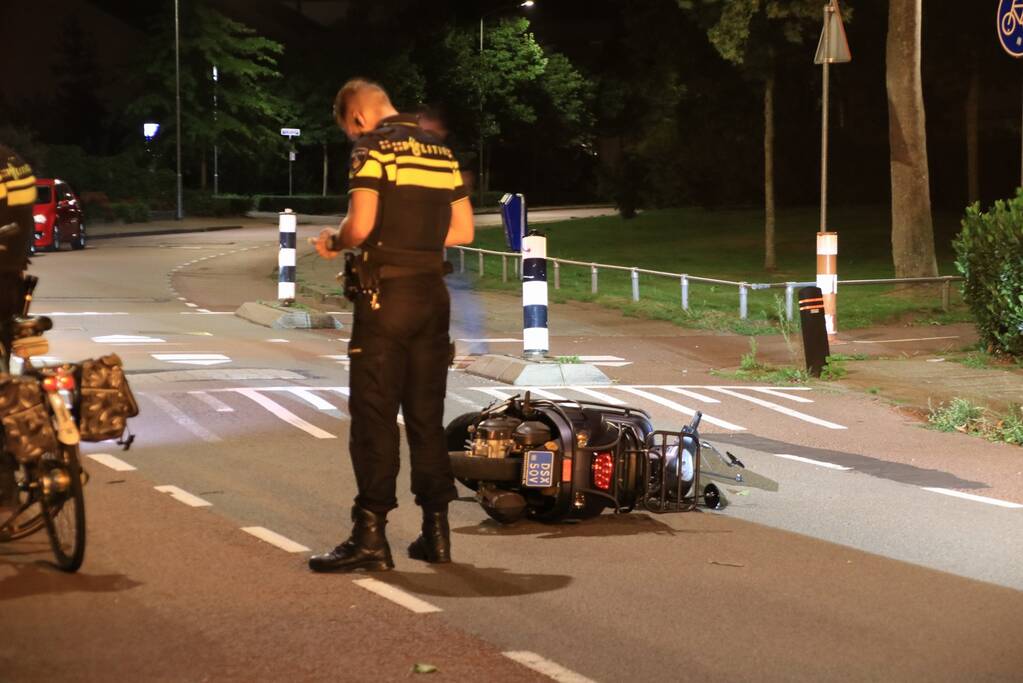 Snorscooter klapt op paal bij oversteekplaats, jonge dame buiten westen