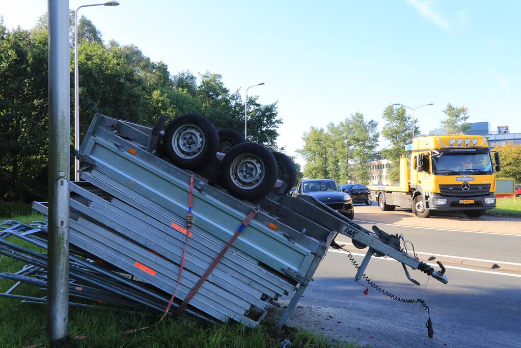 Aanhangwagen met steigerdelen kantelt