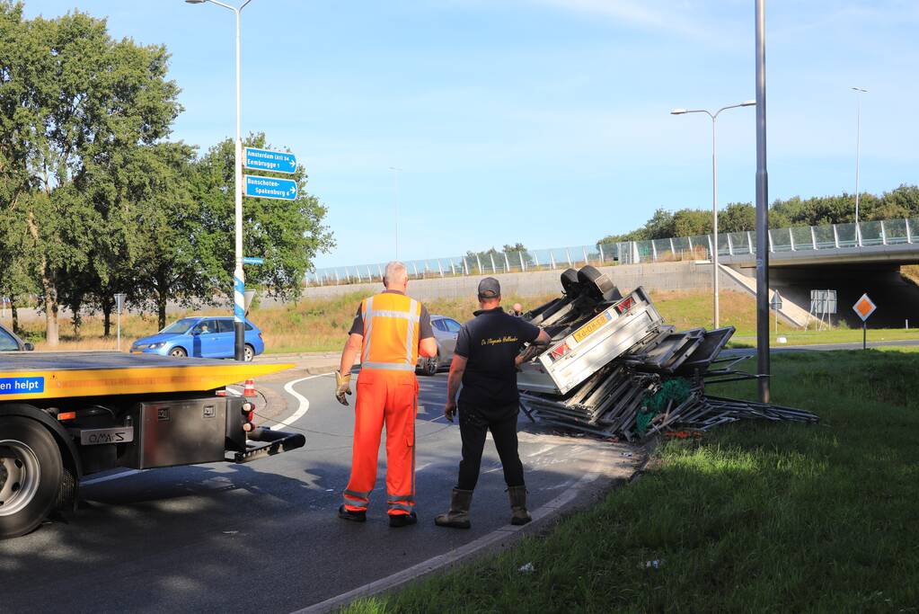 Aanhangwagen met steigerdelen kantelt