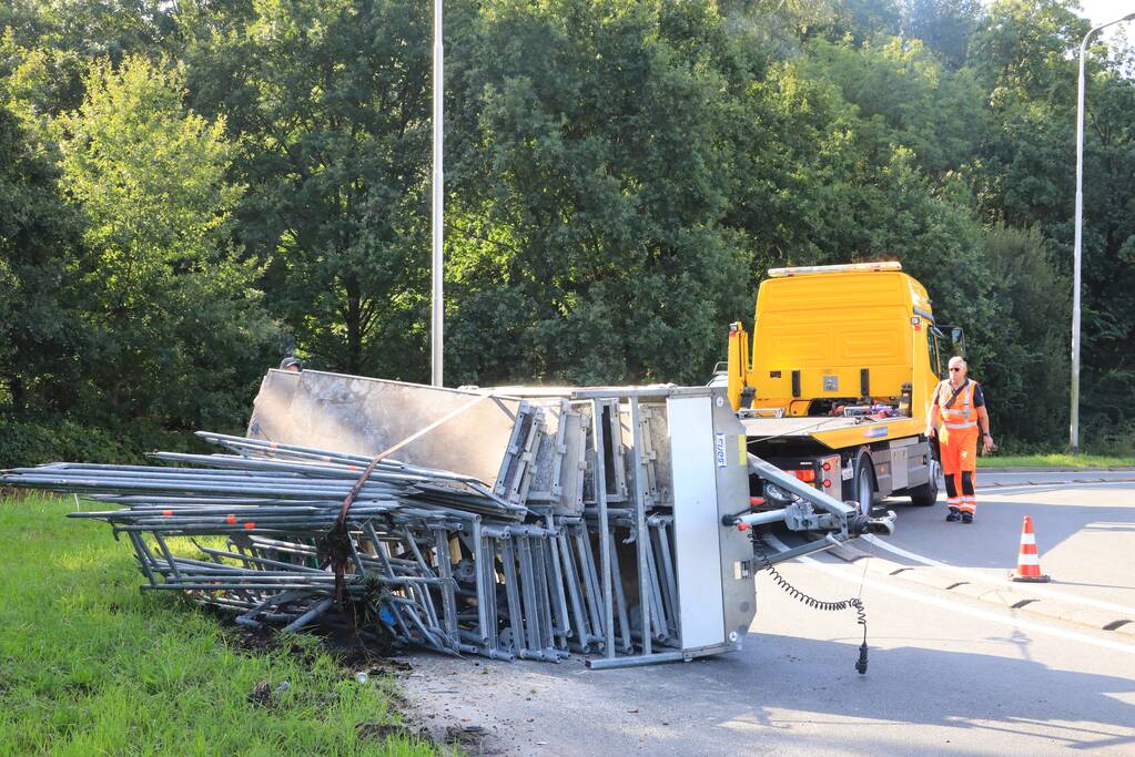 Aanhangwagen met steigerdelen kantelt