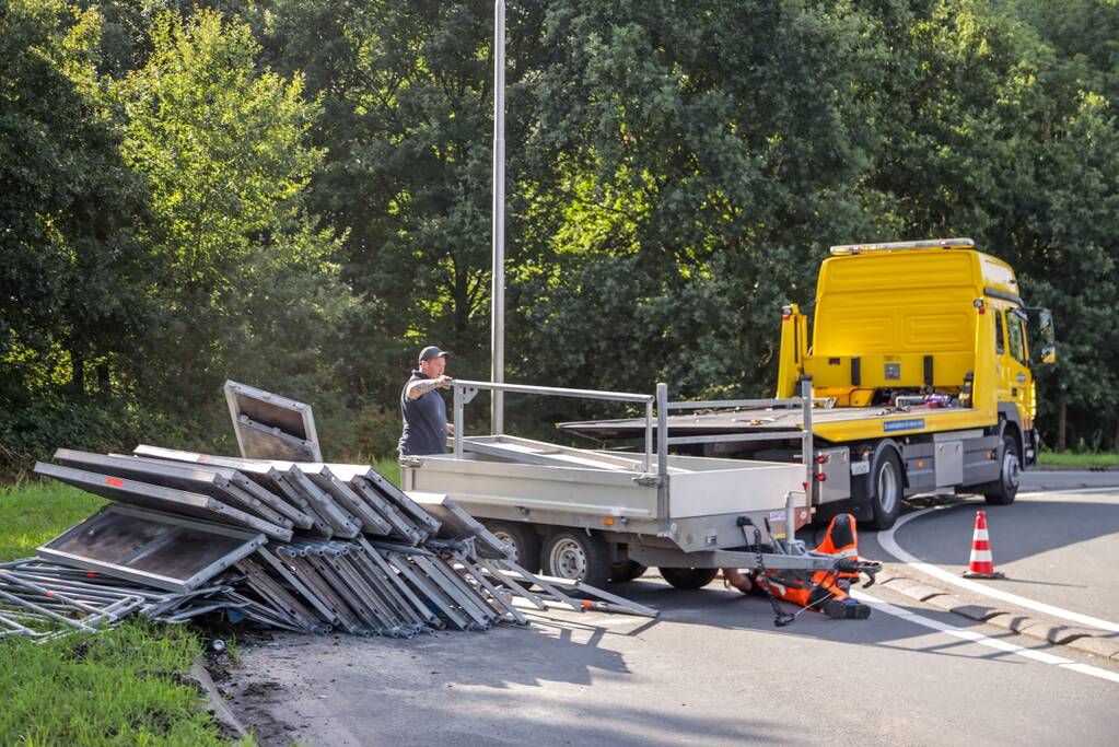 Aanhangwagen met steigerdelen kantelt