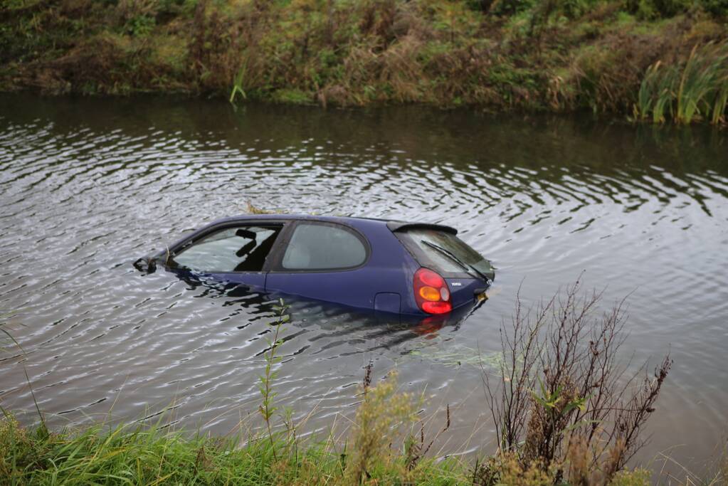 Bestuurder klimt op dak van te water geraakte auto