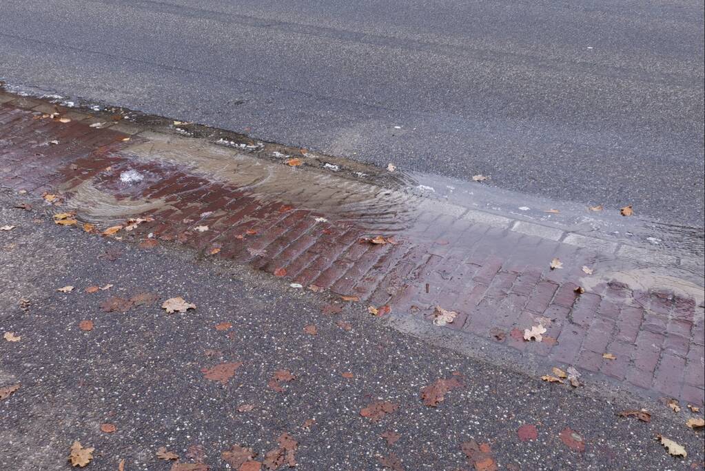 Water borrelt uit de grond door gesprongen waterleiding