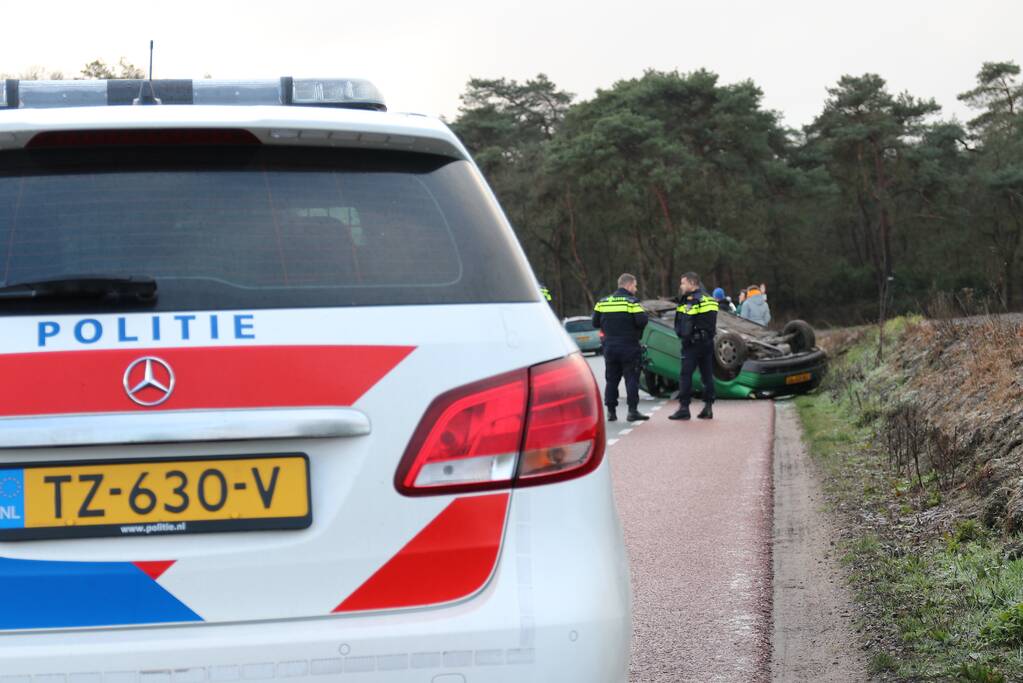 Auto vliegt over de kop op spekgladde weg