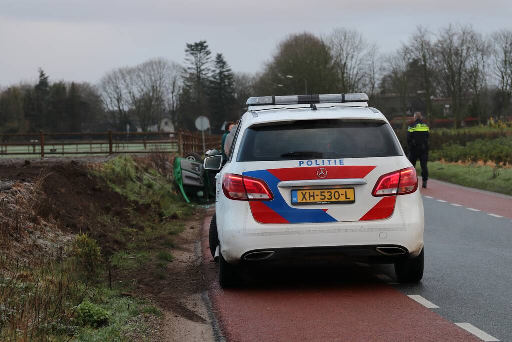 Auto vliegt over de kop op spekgladde weg