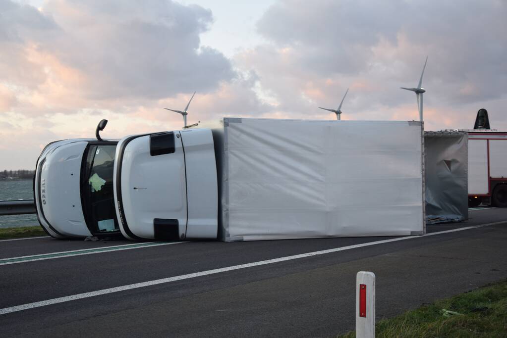 Lege vrachtwagen gekanteld door harde wind op Philipsdam