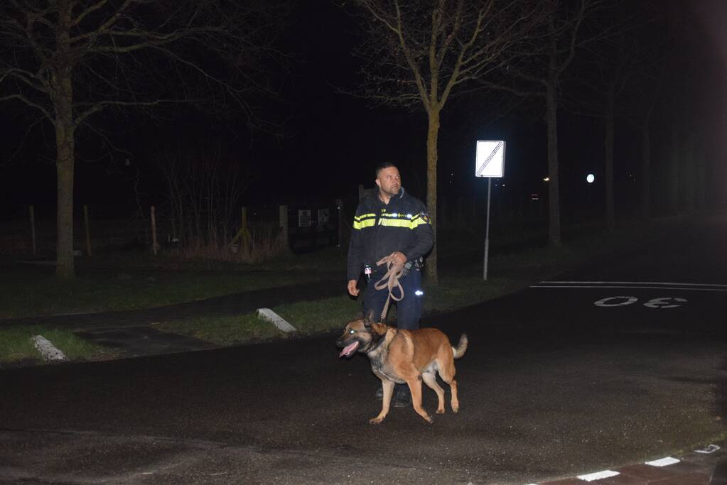 Politieauto en personenauto beschadigd door stenen op rijbaan