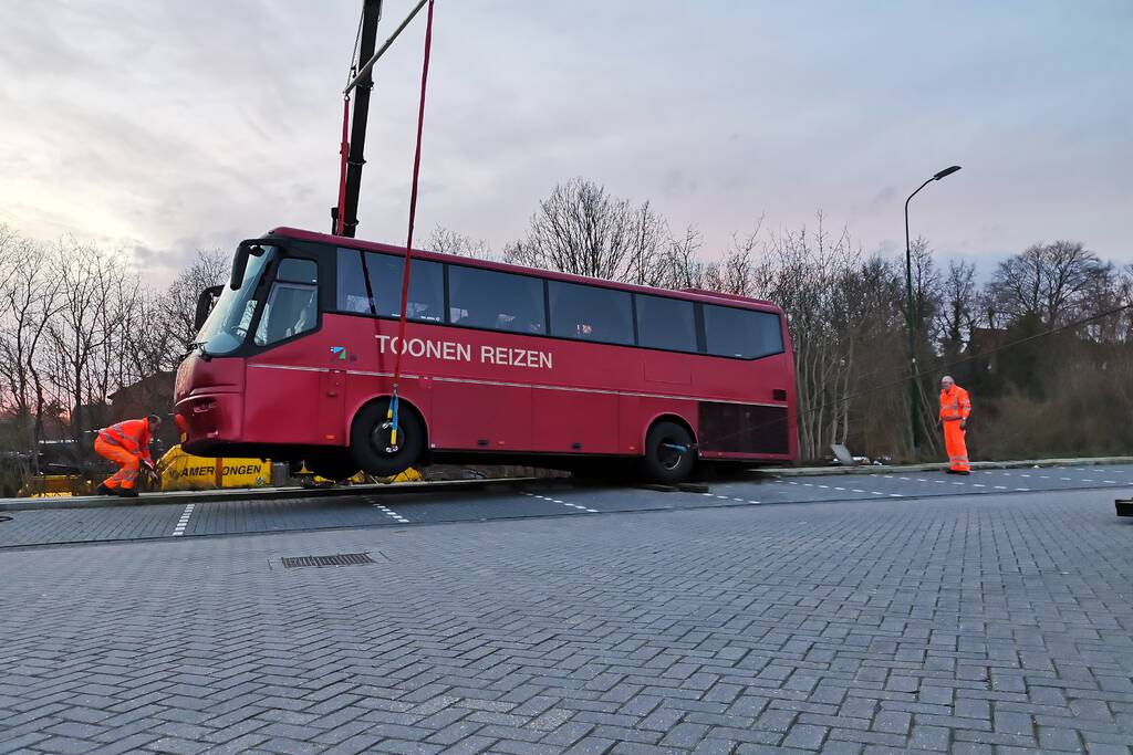 Touringcar rijdt talud af