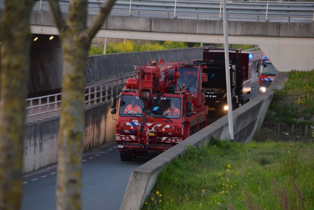 Man bekneld onder as van bedrijfswagen