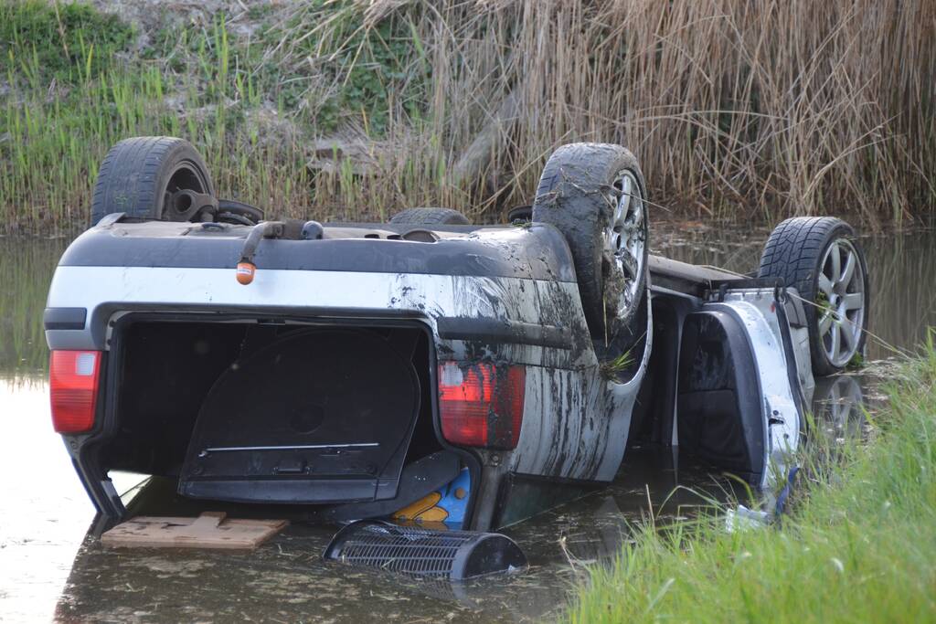 Auto op zijn kop in de sloot