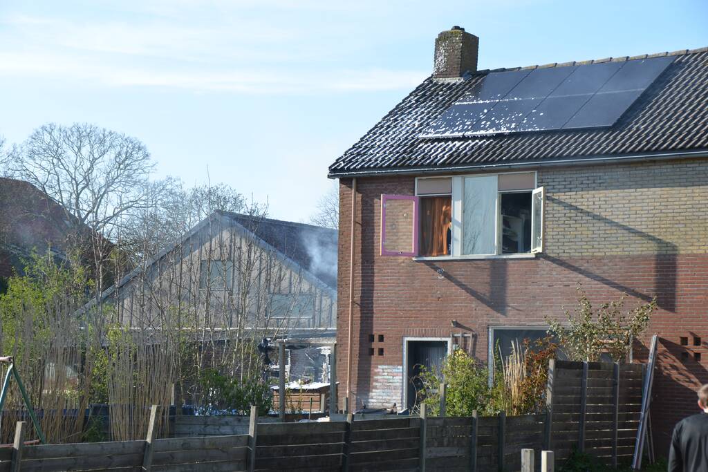 Uitslaande brand in schuur tegen woning aan