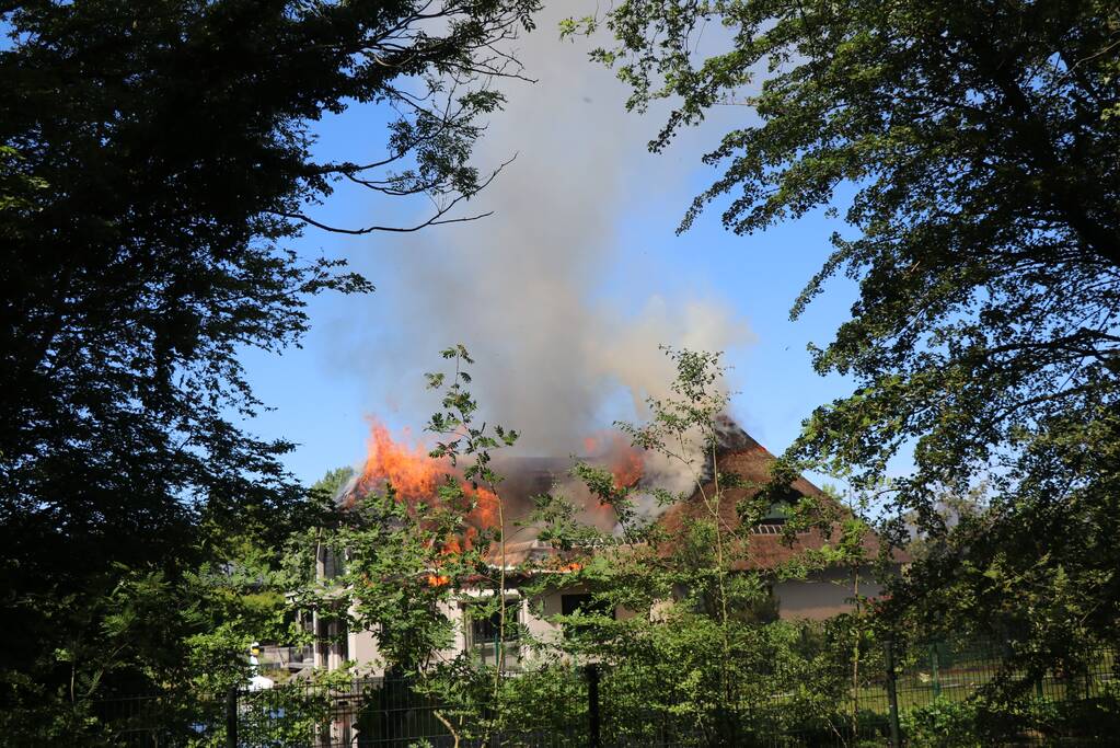 Uitslaande brand in rietendak van woning