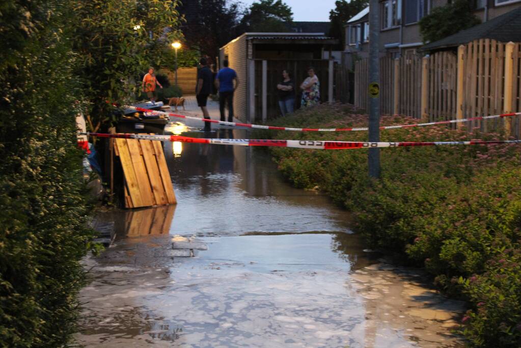 Groot sinkhole en straat vol water na leidingbreuk