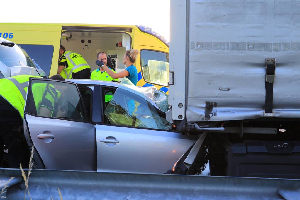 Auto schiet onder oplegger vrachtwagen