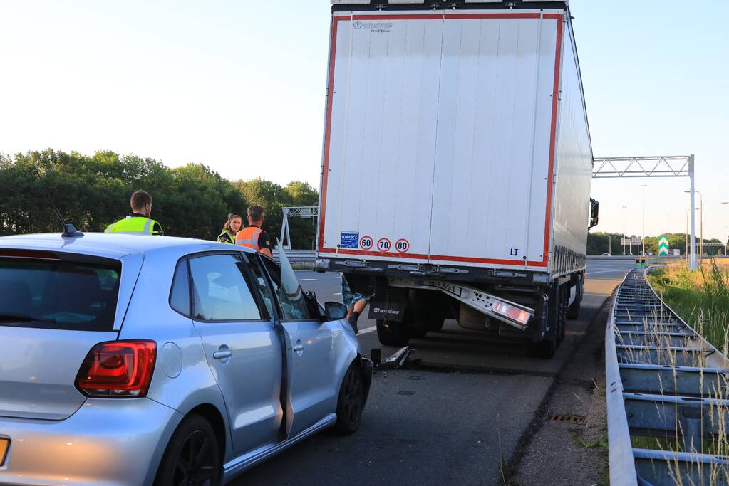 Auto schiet onder oplegger vrachtwagen