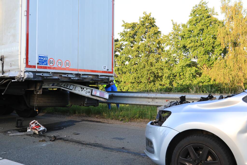 Auto schiet onder oplegger vrachtwagen