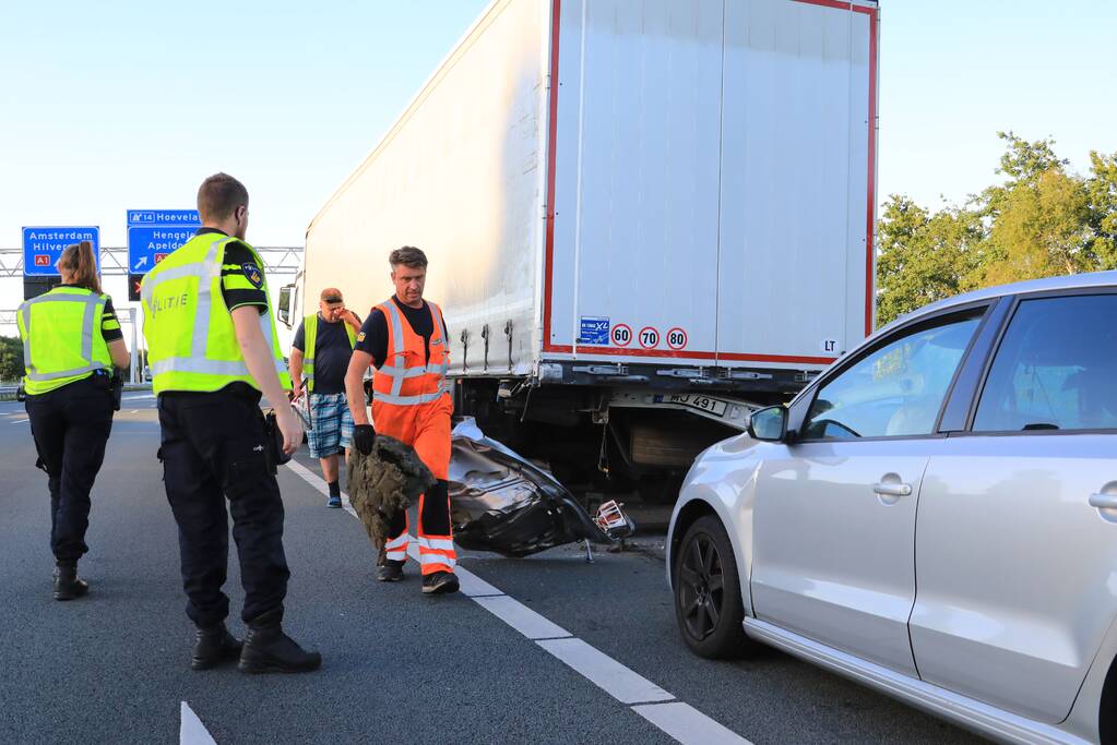 Auto schiet onder oplegger vrachtwagen