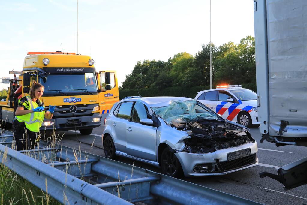 Auto schiet onder oplegger vrachtwagen