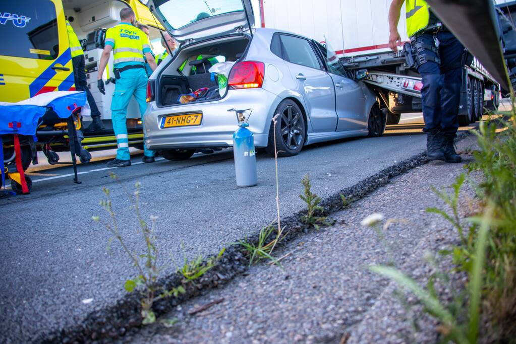 Auto schiet onder oplegger vrachtwagen