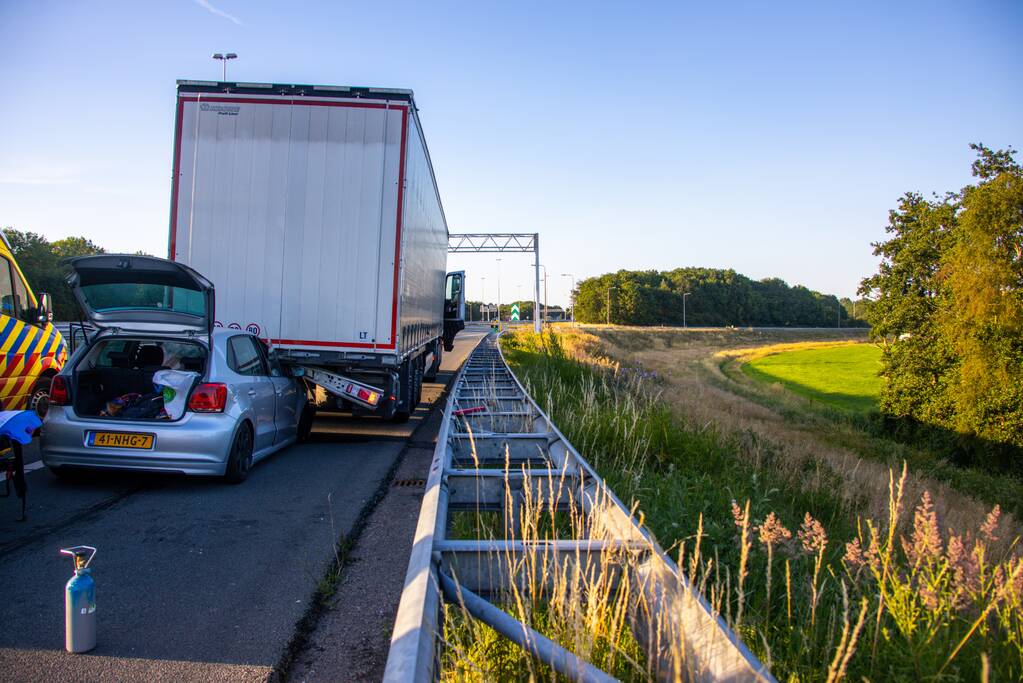 Auto schiet onder oplegger vrachtwagen