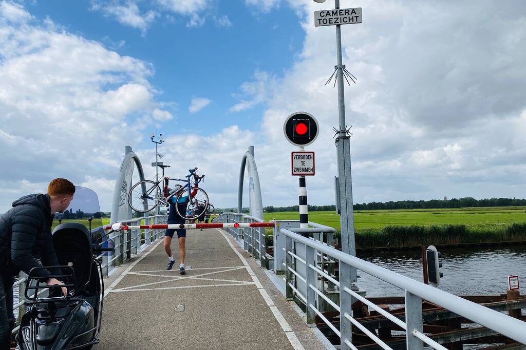 Fietsers kruipen onder slagbomen Malebrug