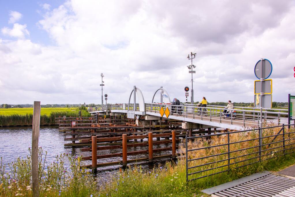 Fietsers kruipen onder slagbomen Malebrug