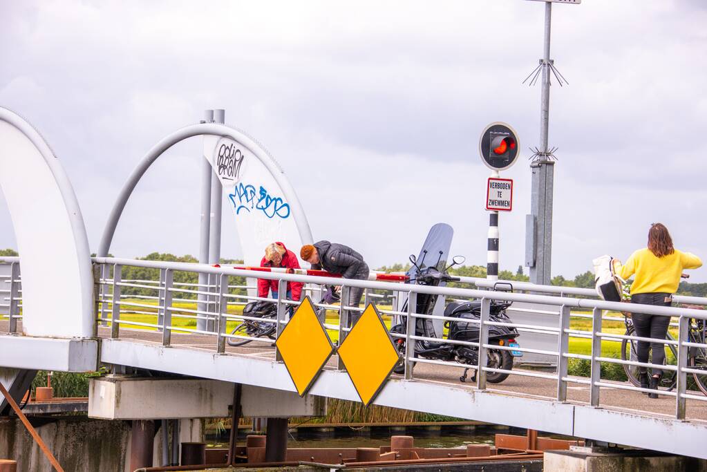 Fietsers kruipen onder slagbomen Malebrug