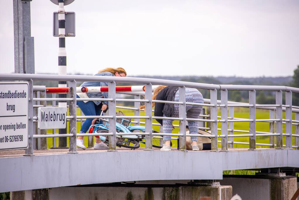 Fietsers kruipen onder slagbomen Malebrug