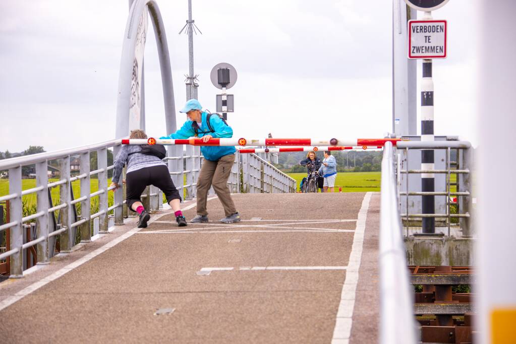 Fietsers kruipen onder slagbomen Malebrug