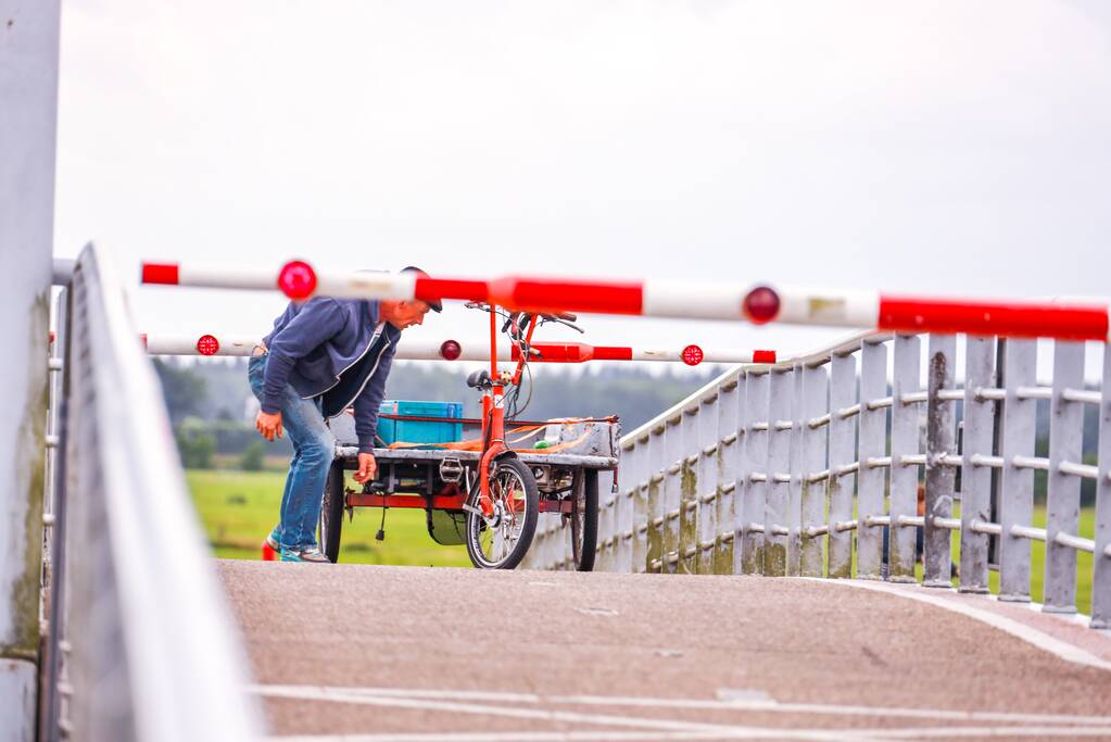 Fietsers kruipen onder slagbomen Malebrug