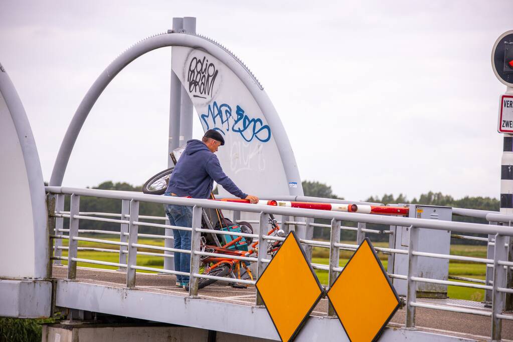 Fietsers kruipen onder slagbomen Malebrug