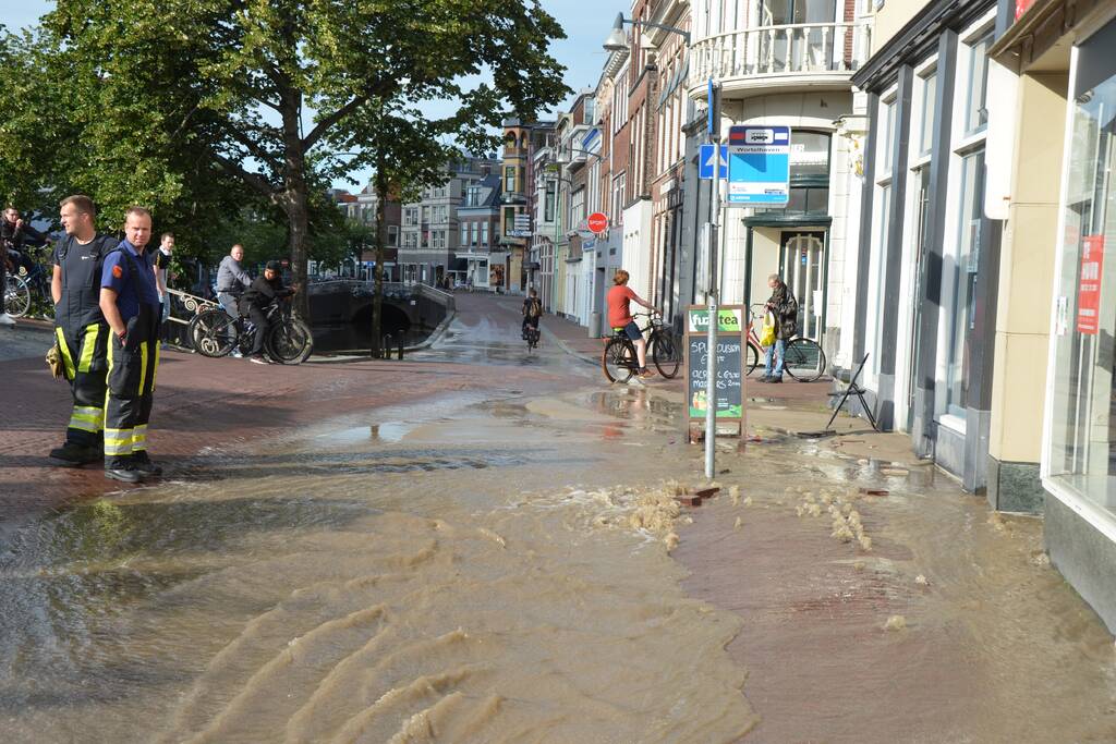 Winkelstraat blank na gesprongen waterleiding