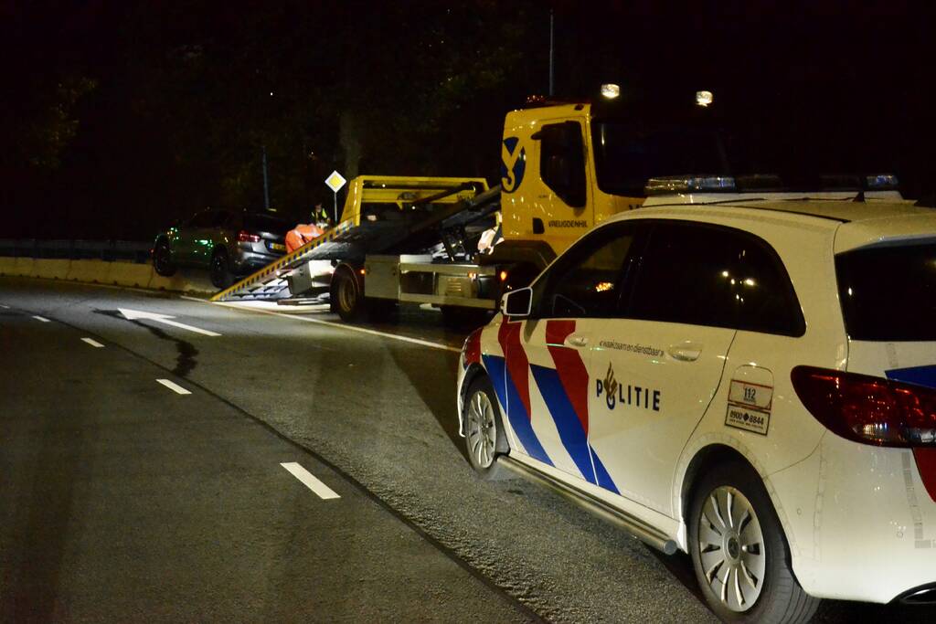 Auto belandt bovenop betonnen afscheiding