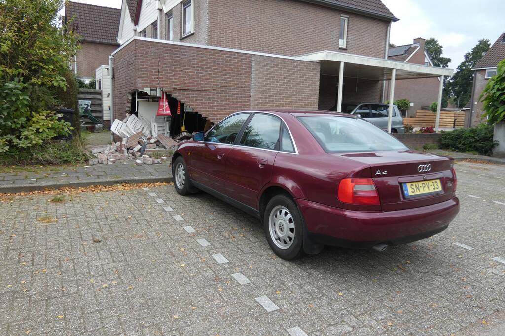 Automobilist rijdt garage in bij wegrijden