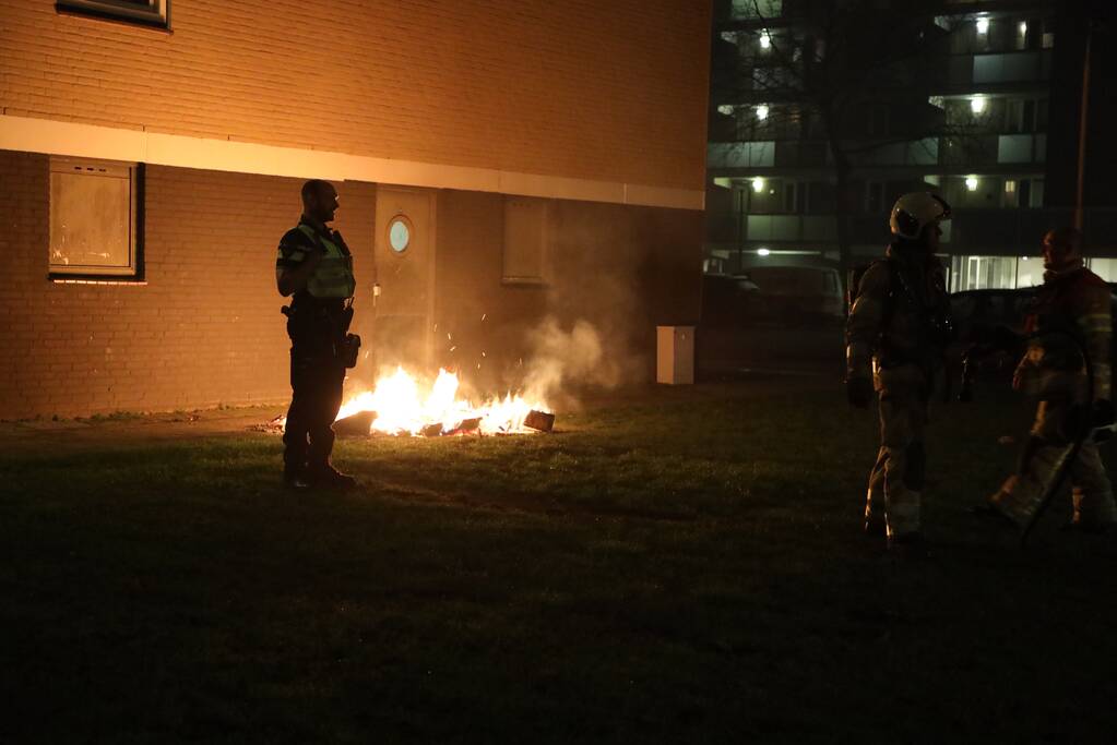 Hout en afval in brand tegen gevel